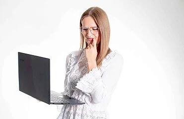 Frau prüft Wechsel in private Krankenversicherung am Laptop | OPTINVEST
